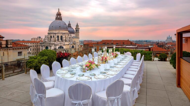 The Redentore rooftop terrace dressed for a wedding banquet at sunset, Santa Maria della Salute beyond, The Gritti Palace