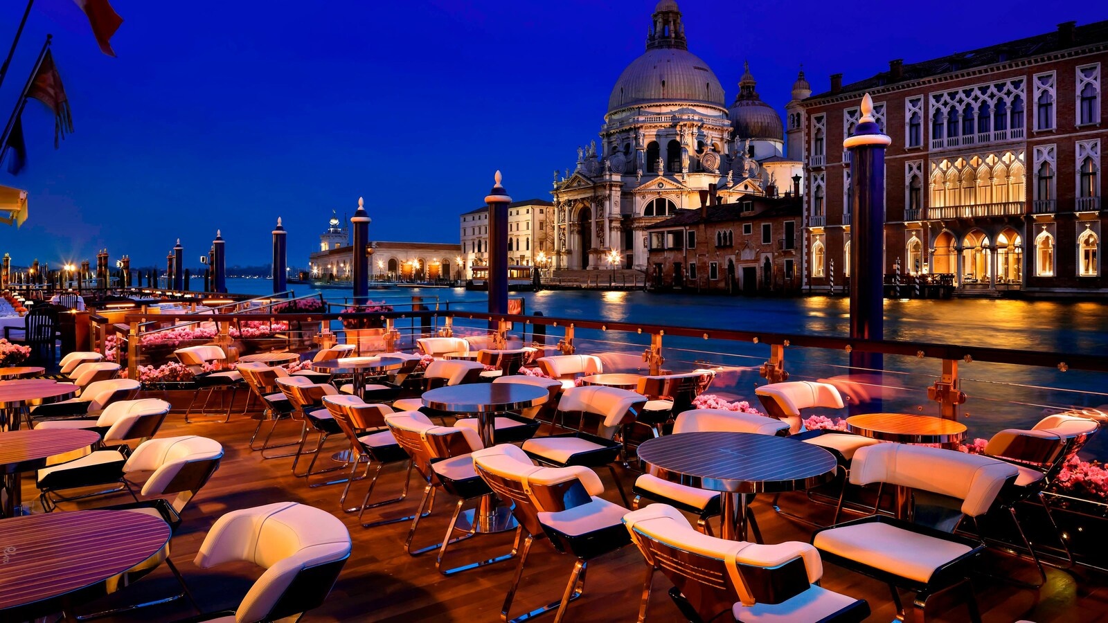 The canal-side terrace laid for dinner at night, candlelit above the water, The Gritti Palace