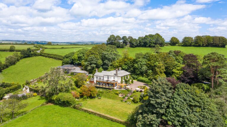 The hotel and its five acres of gardens seen from the air, surrounded by fields on the Devon side of the Tamar Valley, The Horn Of Plenty