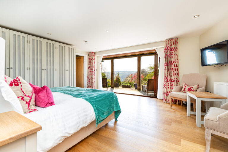 Room 11, a Best room in the New Coach House, with folding glass doors open to its west-facing terrace, The Horn Of Plenty