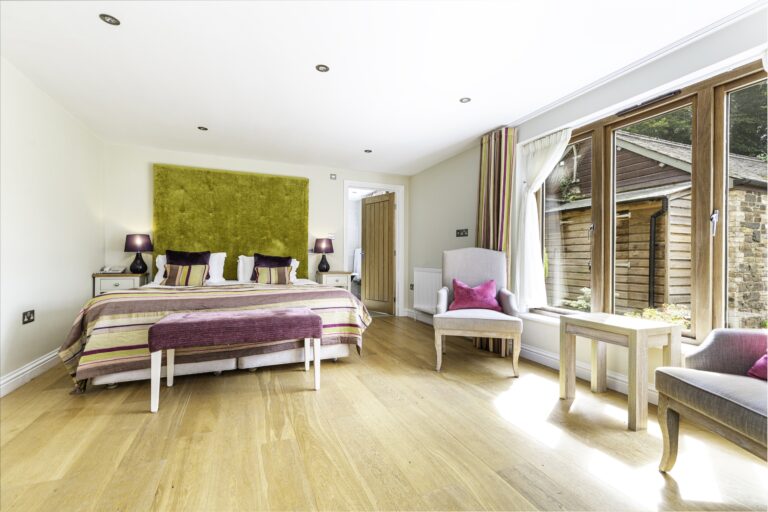 Room 12, a Deluxe room in the New Coach House, with a large bed and glass doors to the courtyard, The Horn Of Plenty