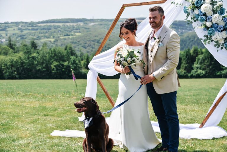 A couple at a draped ceremony frame on the lawn, with their dog on the lead beside them, The Horn Of Plenty