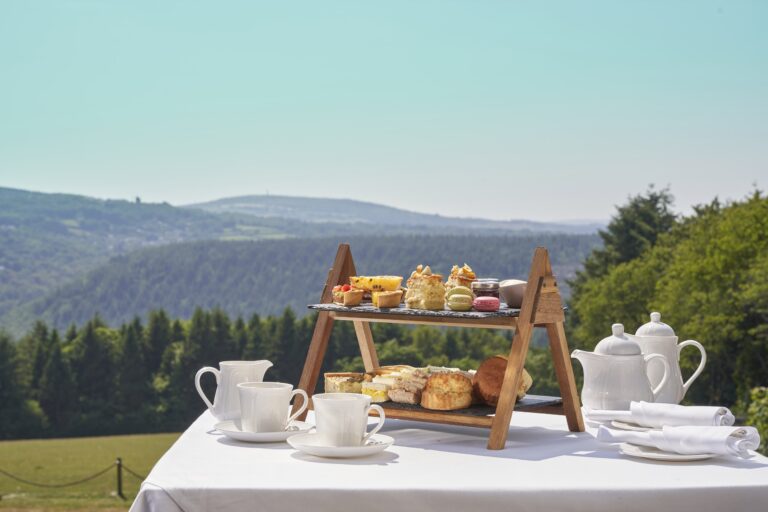 Afternoon tea on a stand, set on a table on the lawn with the valley behind, The Horn Of Plenty