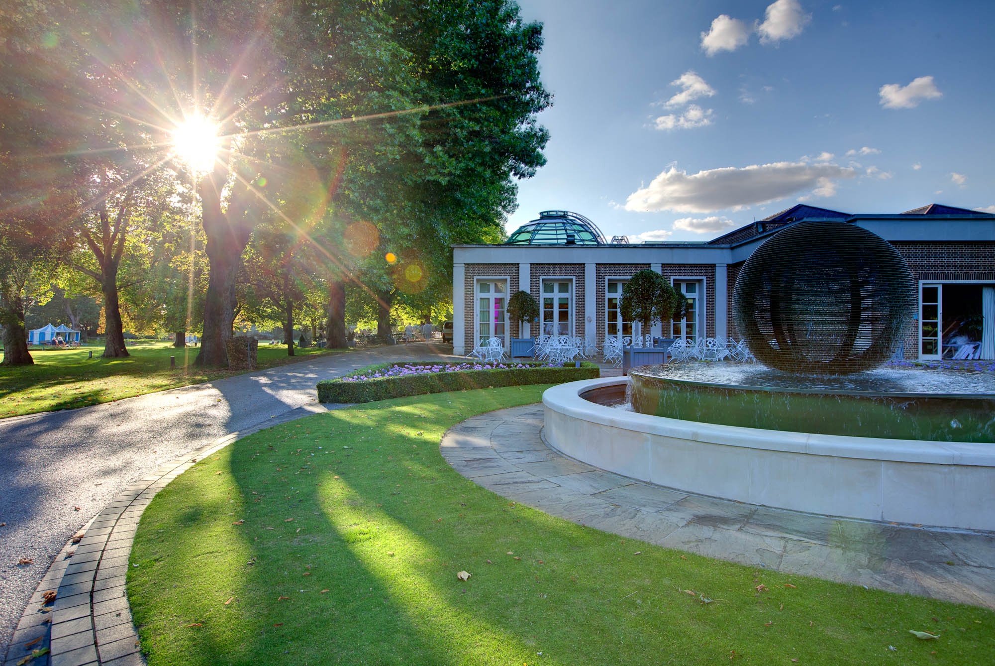 Palm Court’s glass dome and the Sunken Garden fountain, caught in golden evening light, The Hurlingham Club