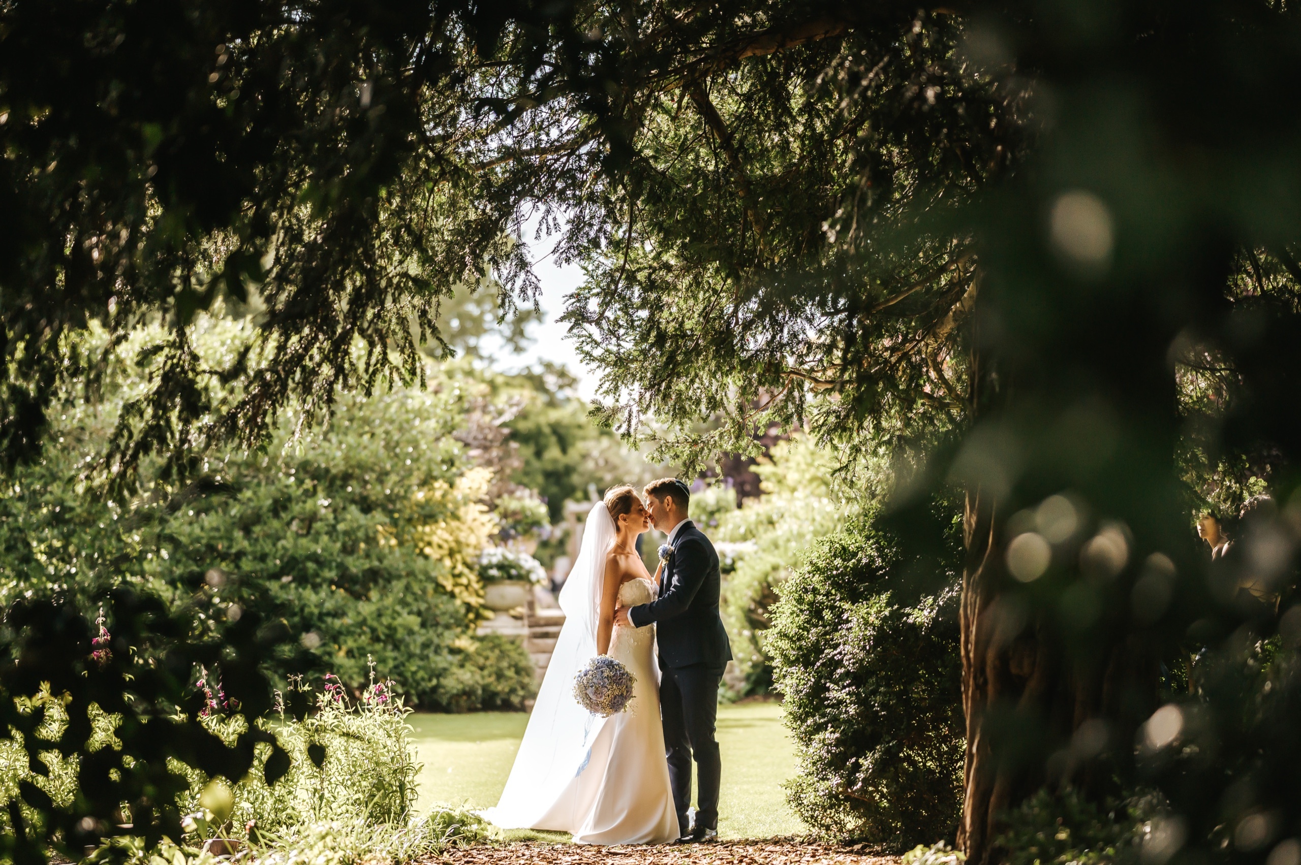 A couple embracing beneath the trees in the club gardens, The Hurlingham Club