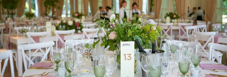 A wedding breakfast table laid with green glassware and a garden centrepiece, The Hurlingham Club