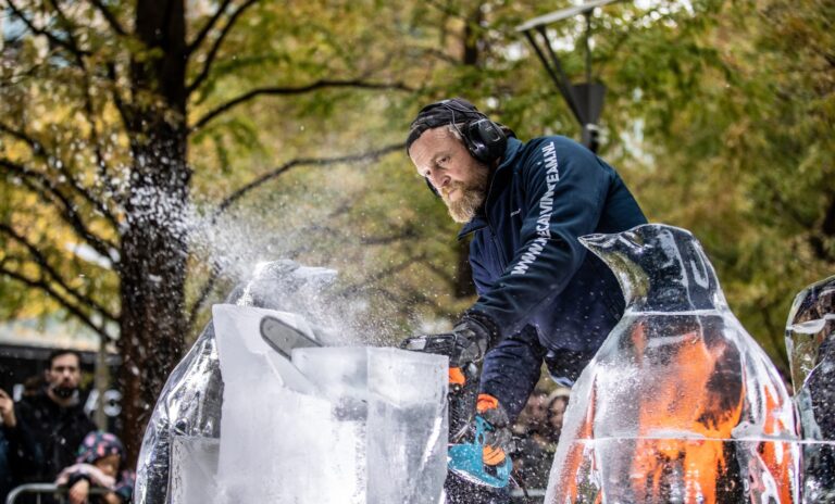 A sculptor carving a block of ice in the open air, The Ice Box