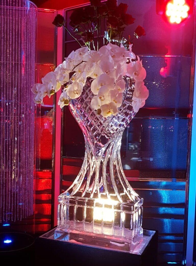 A heart shaped ice vase filled with white orchids, The Ice Box