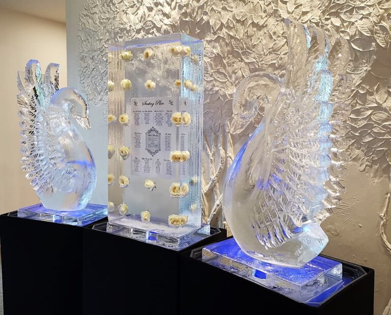 Two hand-carved ice swans either side of an ice block seating plan at a wedding, The Ice Box