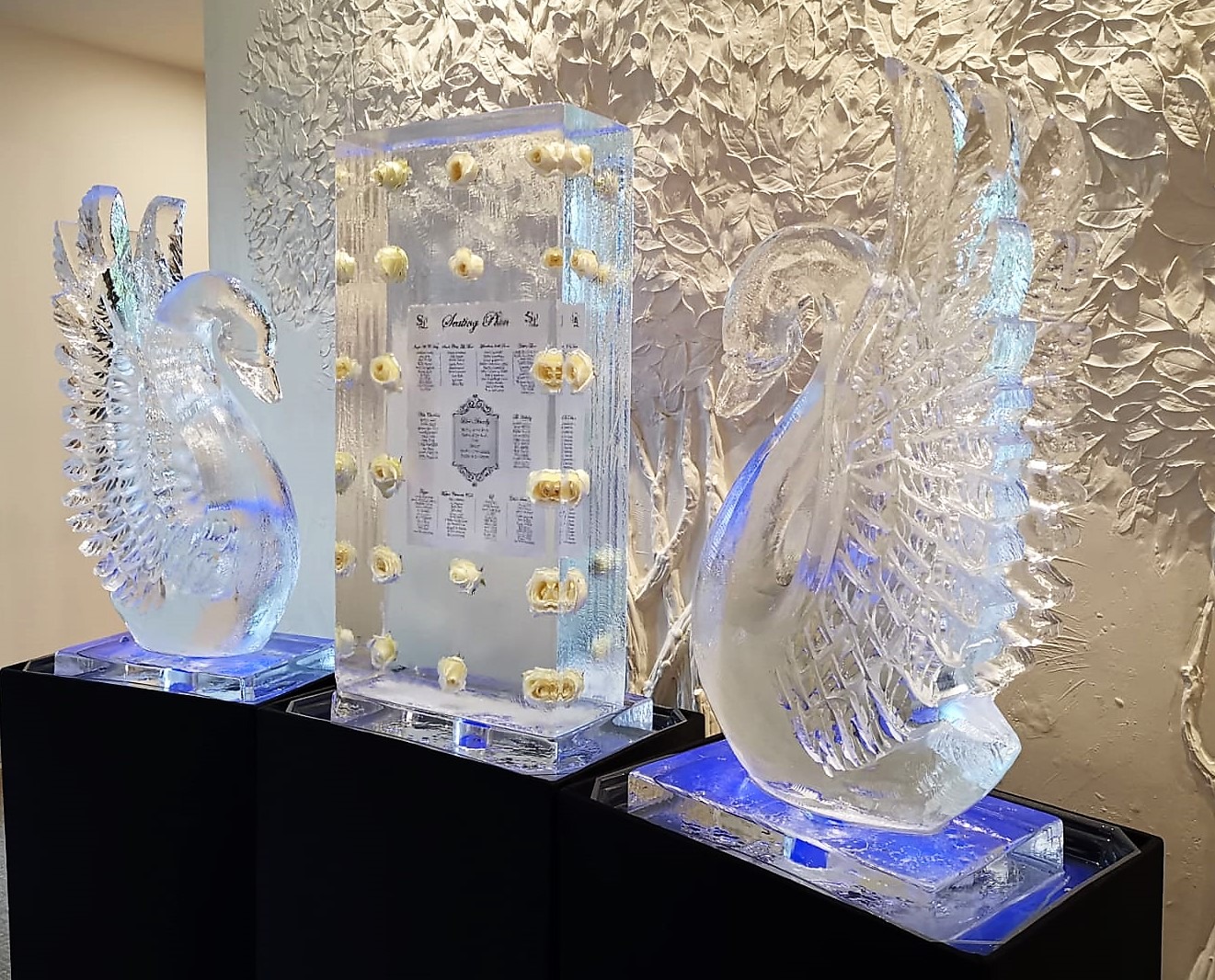 Two hand-carved ice swans either side of an ice block seating plan at a wedding, The Ice Box
