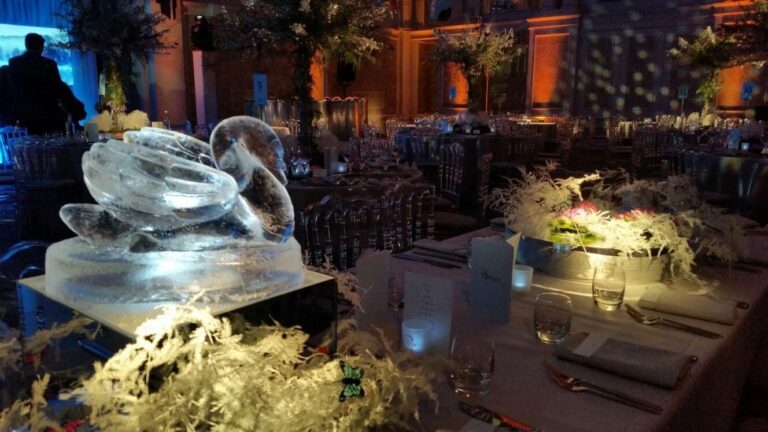 An ice swan table centre on a banquet table lit by candles, The Ice Box