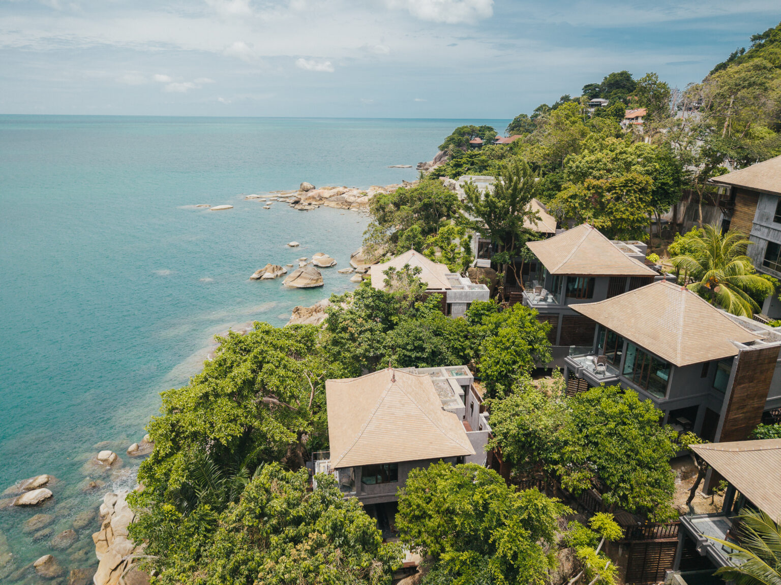 Villa roofs stepping down the hillside to the Gulf of Thailand