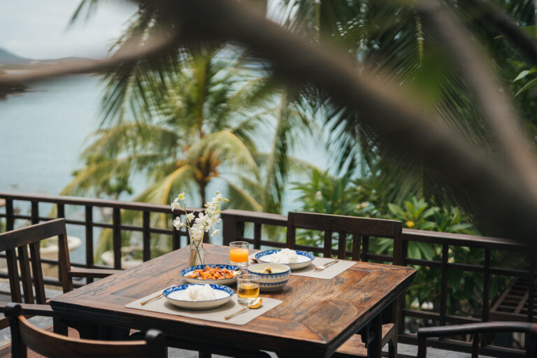 Breakfast table on a wooden terrace above the sea, The Kala Samui
