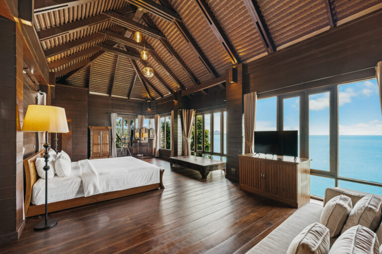 Villa bedroom and seating area under a pitched timber ceiling, The Kala Samui