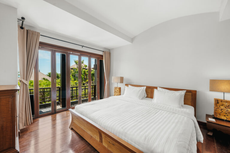 Bedroom with a king bed and balcony doors, The Kala Samui