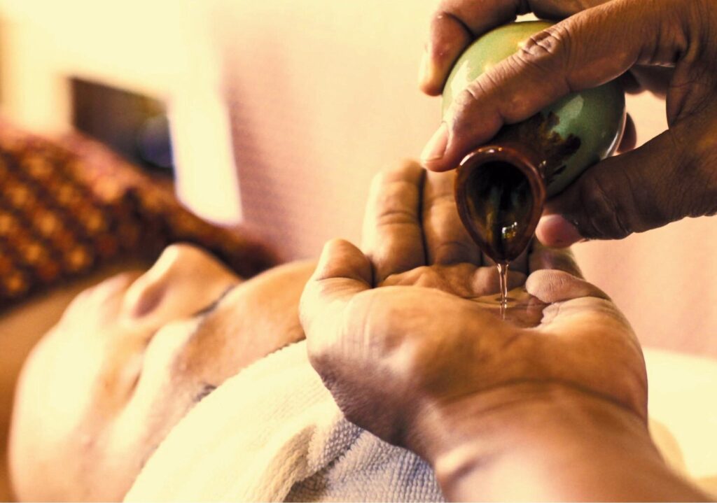Massage oil poured into a therapist's hands, The Kala Samui