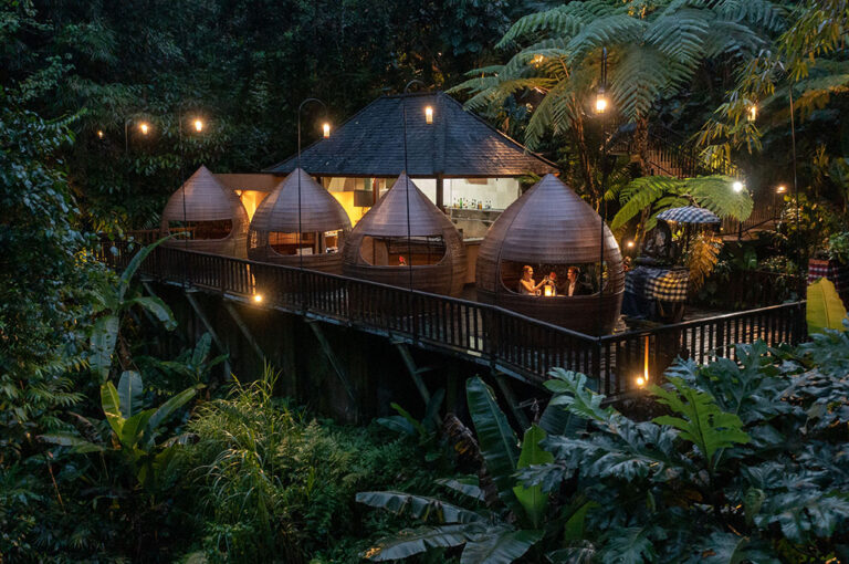 Canyon Jetty dining huts lit at night, The Kayon Jungle Resort