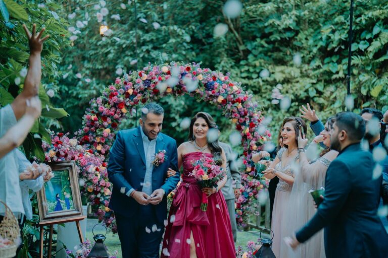 A flower-shower celebration beneath a floral arch, The Kayon Ubud Resort