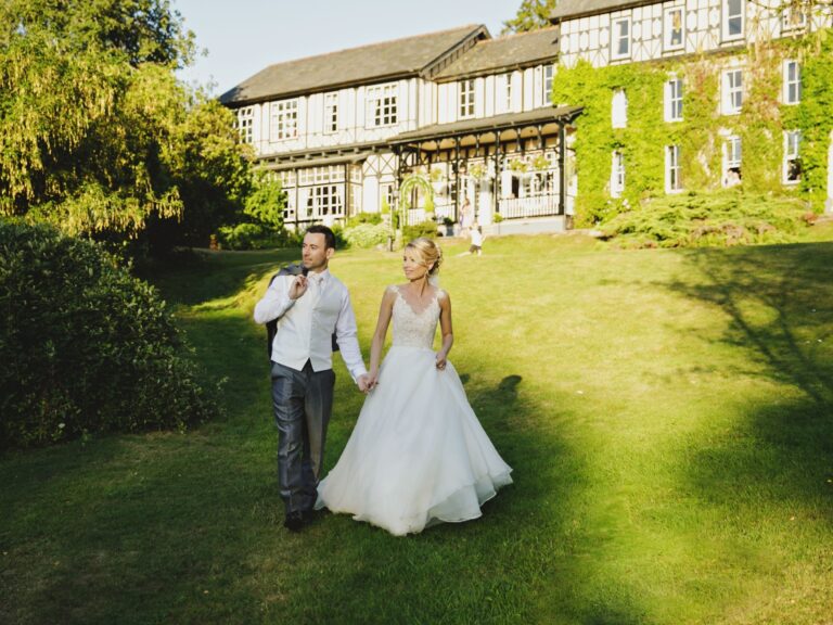 A couple on the sunlit lawn, house behind, The Lake Country House Hotel & Spa