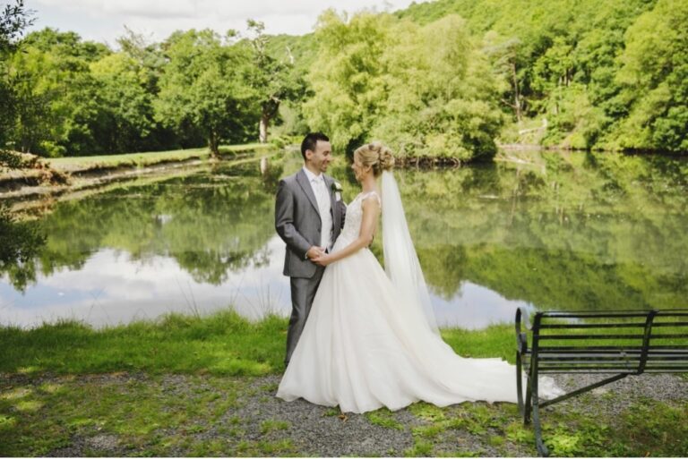 Bride and groom by the lake, reflected in still water, The Lake Country House Hotel & Spa