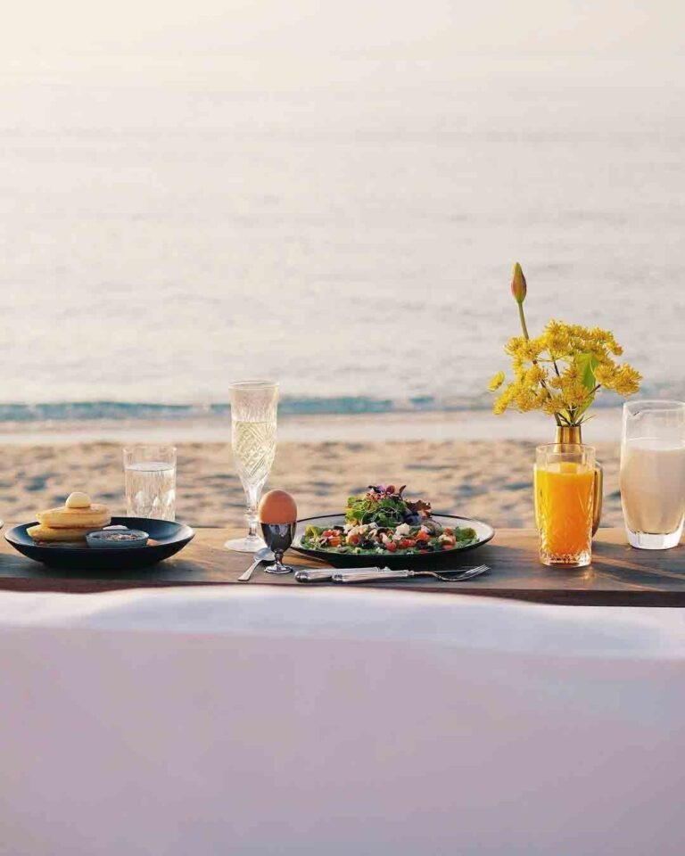 Breakfast laid on a table on the beach, The Library
