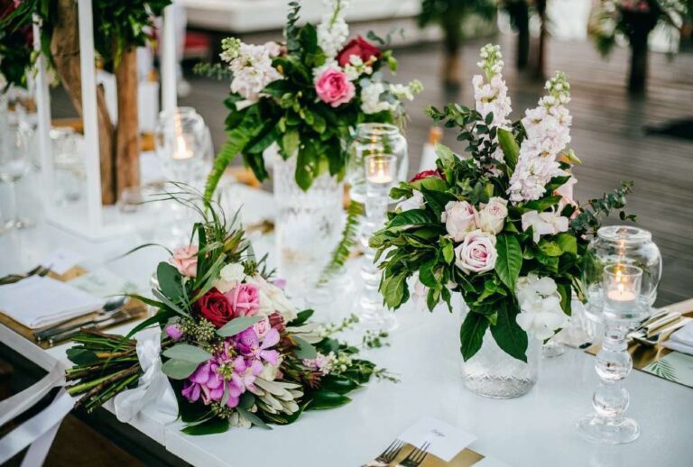 Reception table with flower arrangements and place settings, The Library