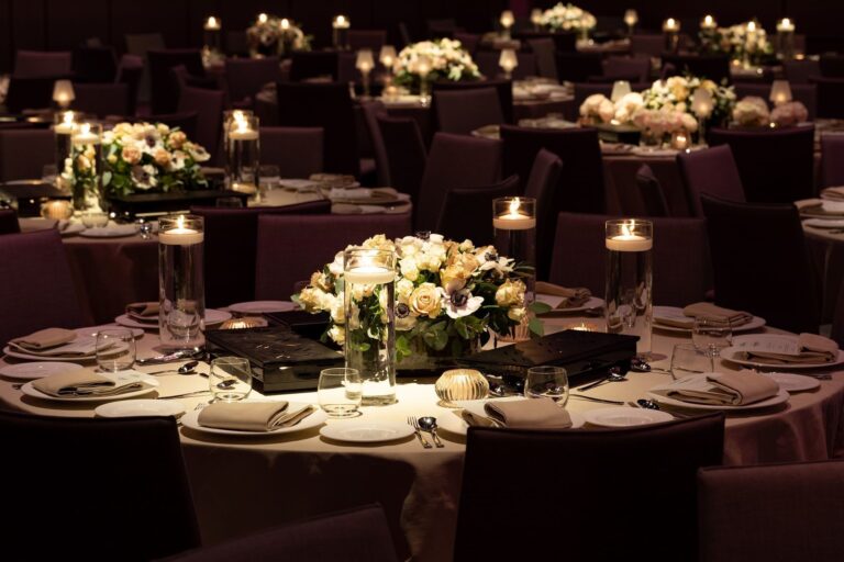 A round table in the Ballroom with a low arrangement of white roses and floating candles, The Londoner