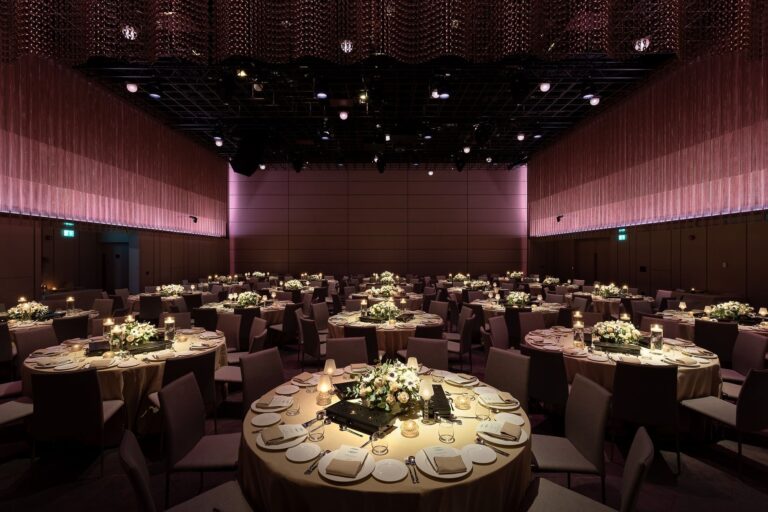 The Ballroom laid for a wedding dinner with round tables, white flowers and candles, The Londoner