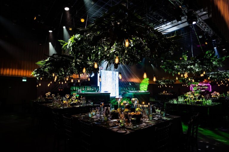 The Ballroom dressed with hanging greenery and festoon lights over dinner tables, The Londoner