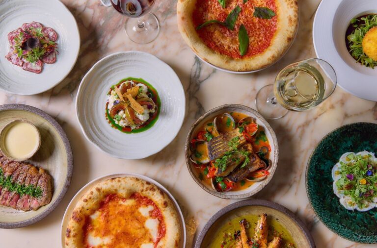 A spread of May Fair Kitchen small plates and pizzas on a marble table, The May Fair
