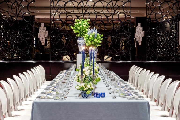A long banquet table in the Danziger Suite with blue and white vases, blue candles and green hydrangeas, The May Fair