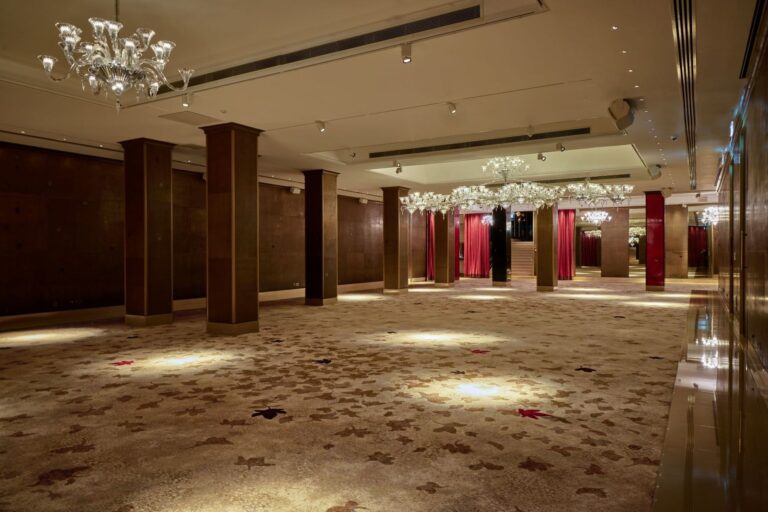 The Crystal Ballroom cleared of furniture, showing the columns, patterned carpet and chandeliers, The May Fair