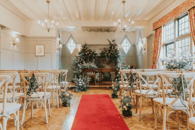The Oakwood Room aisle, a red runner on parquet under leaded diamond windows, The Montagu Arms Hotel