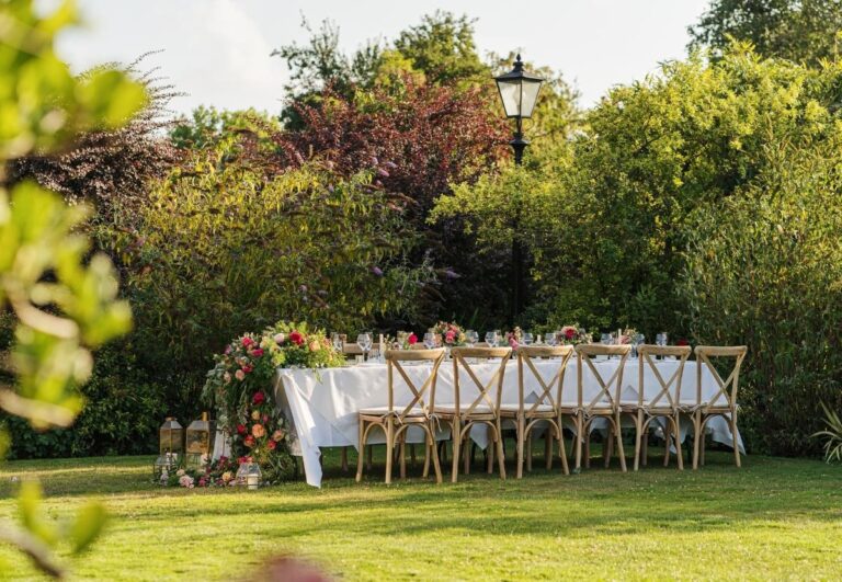 An outdoor wedding table with a floral arch on the lawn, The Montagu Arms Hotel