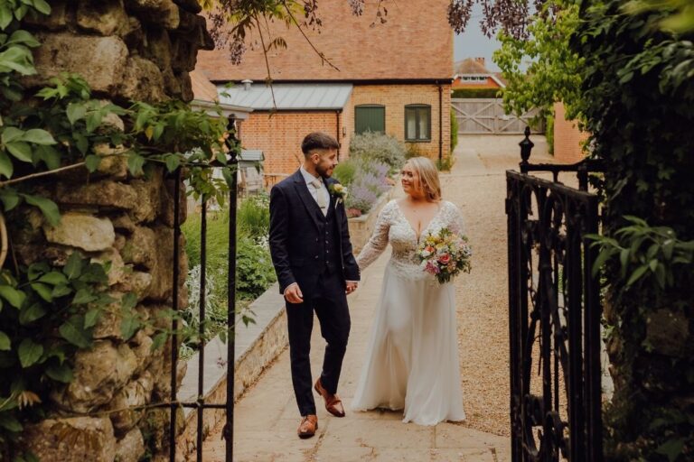 The couple walking out through the ivy-covered stone garden archway, The Montagu Arms Hotel