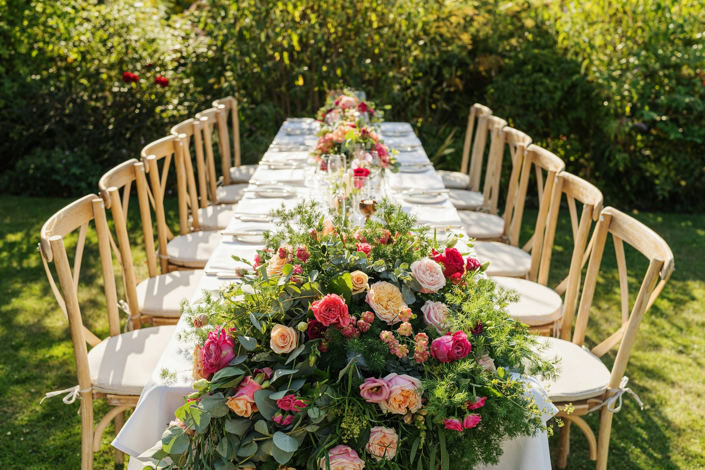 A long wedding table dressed with garden roses and eucalyptus on the lawn, The Montagu Arms Hotel