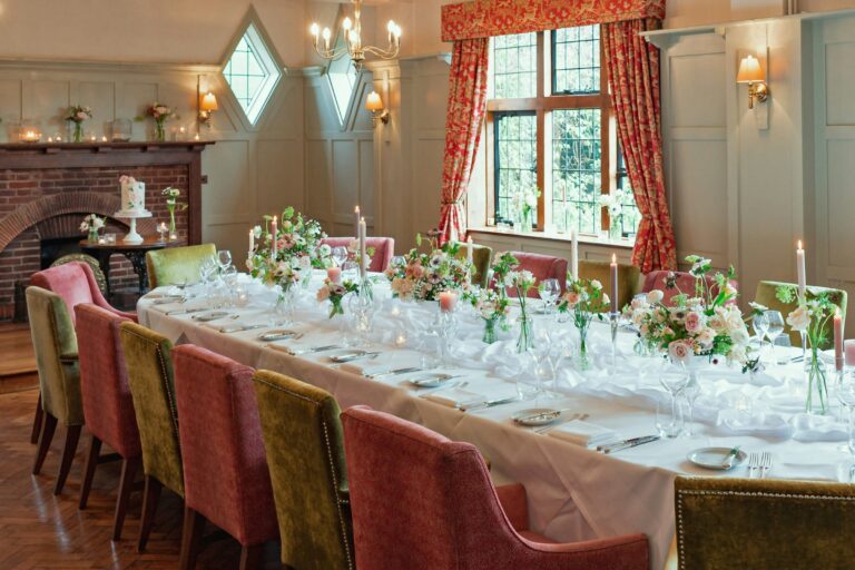 The wedding breakfast in the Oakwood Room, a long table with candles and low florals, The Montagu Arms Hotel