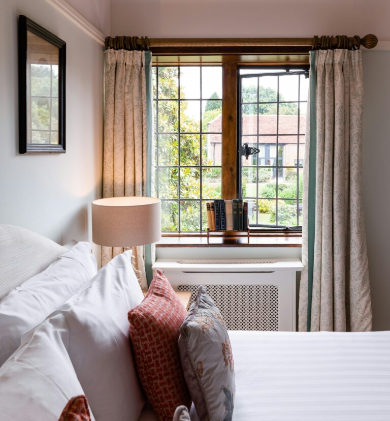 A house bedroom, mullioned window and layered cushions, The Montagu Arms Hotel