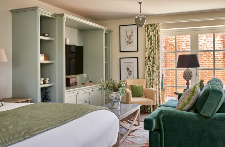 The Courtyard Suite, bed with green sofa and fitted shelving, The Montagu Arms Hotel