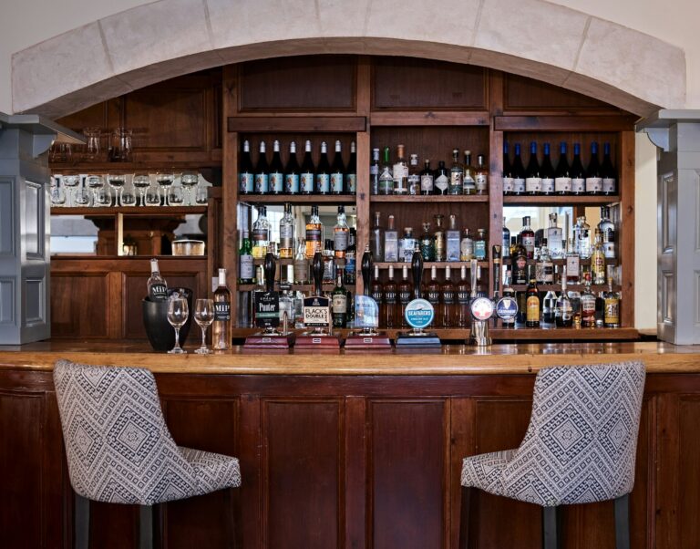 The bar at Monty's, a mahogany counter and back-lit spirits, The Montagu Arms Hotel