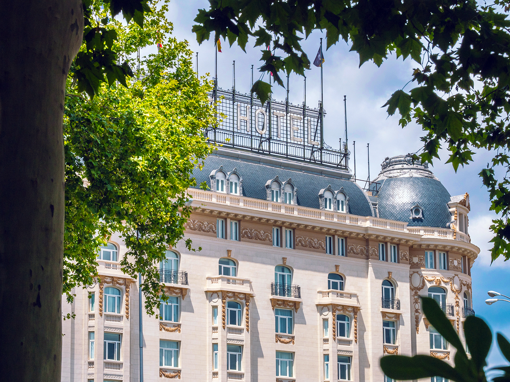 The corner dome and upper floors seen through the trees, The Palace, a Luxury Collection Hotel, Madrid