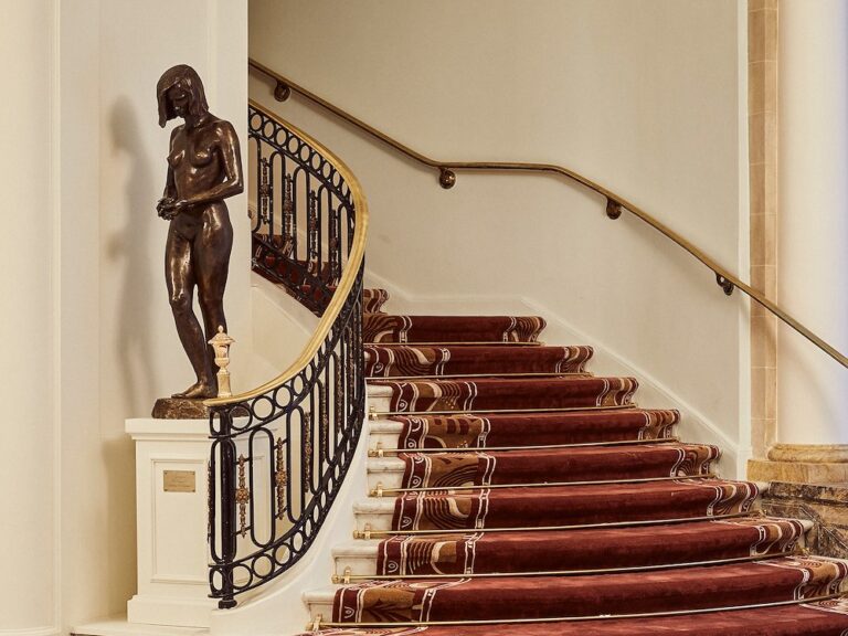 The red carpeted staircase with its bronze figure, The Palace, a Luxury Collection Hotel, Madrid