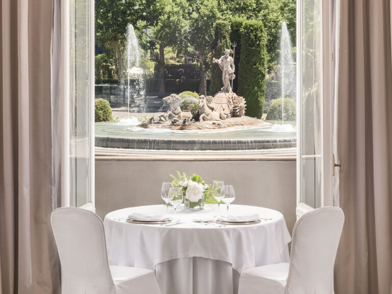 A table set at a window overlooking the Neptune Fountain, The Palace, a Luxury Collection Hotel, Madrid