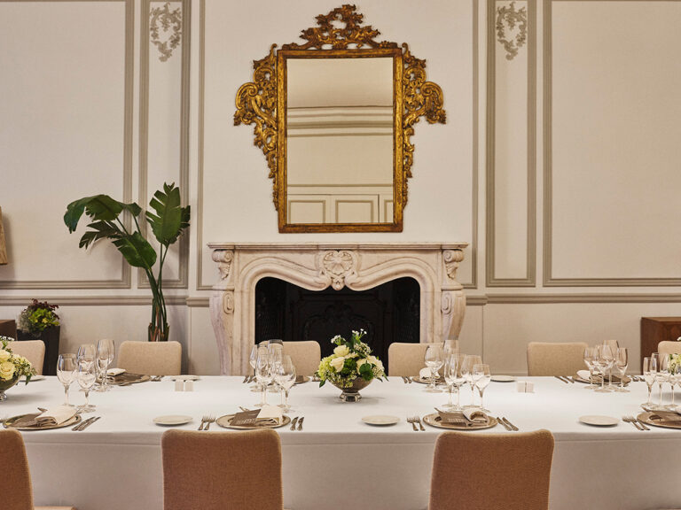 A banquet table set before a gilt mirror and fireplace, The Palace, a Luxury Collection Hotel, Madrid