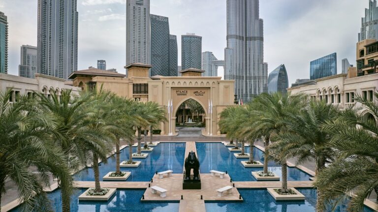 The hotel courtyard with its long pools and palm trees, with the Burj Khalifa beyond, The Palace Downtown Dubai