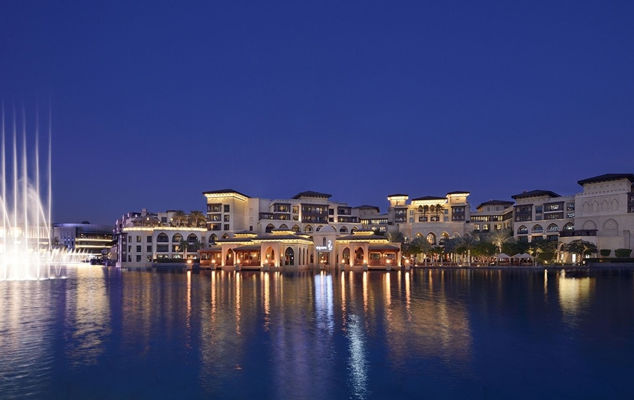 The hotel on the edge of Burj Lake at night, with the Dubai Fountain in play, The Palace Downtown Dubai