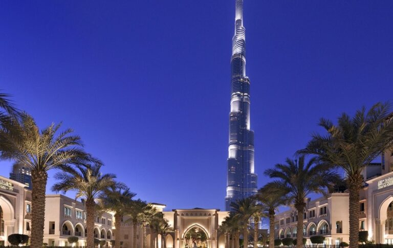 The Burj Khalifa rising above the palm-lined hotel grounds at dusk, The Palace Downtown Dubai