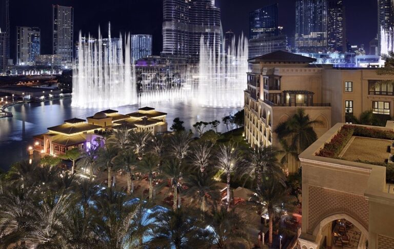 The Dubai Fountain lit at night, seen across the hotel grounds, The Palace Downtown Dubai