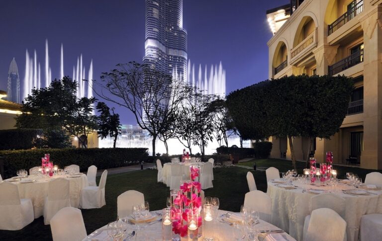 Round-table dinner on the lakeside lawn of the Palace Gardens at night, The Palace Downtown Dubai