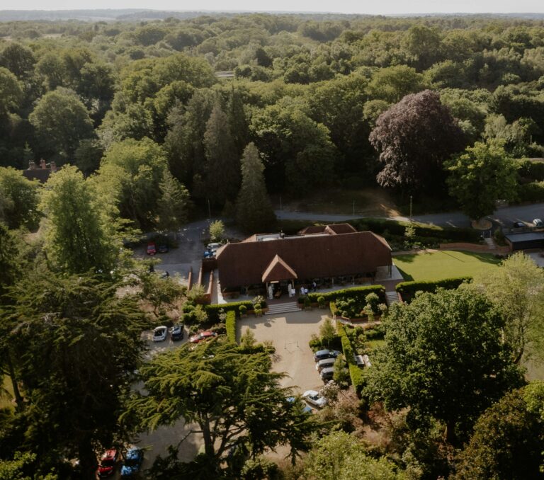 The barn, its car parks and lawn from the air, surrounded by the woodland of Snelsmore Common, The Post Barn